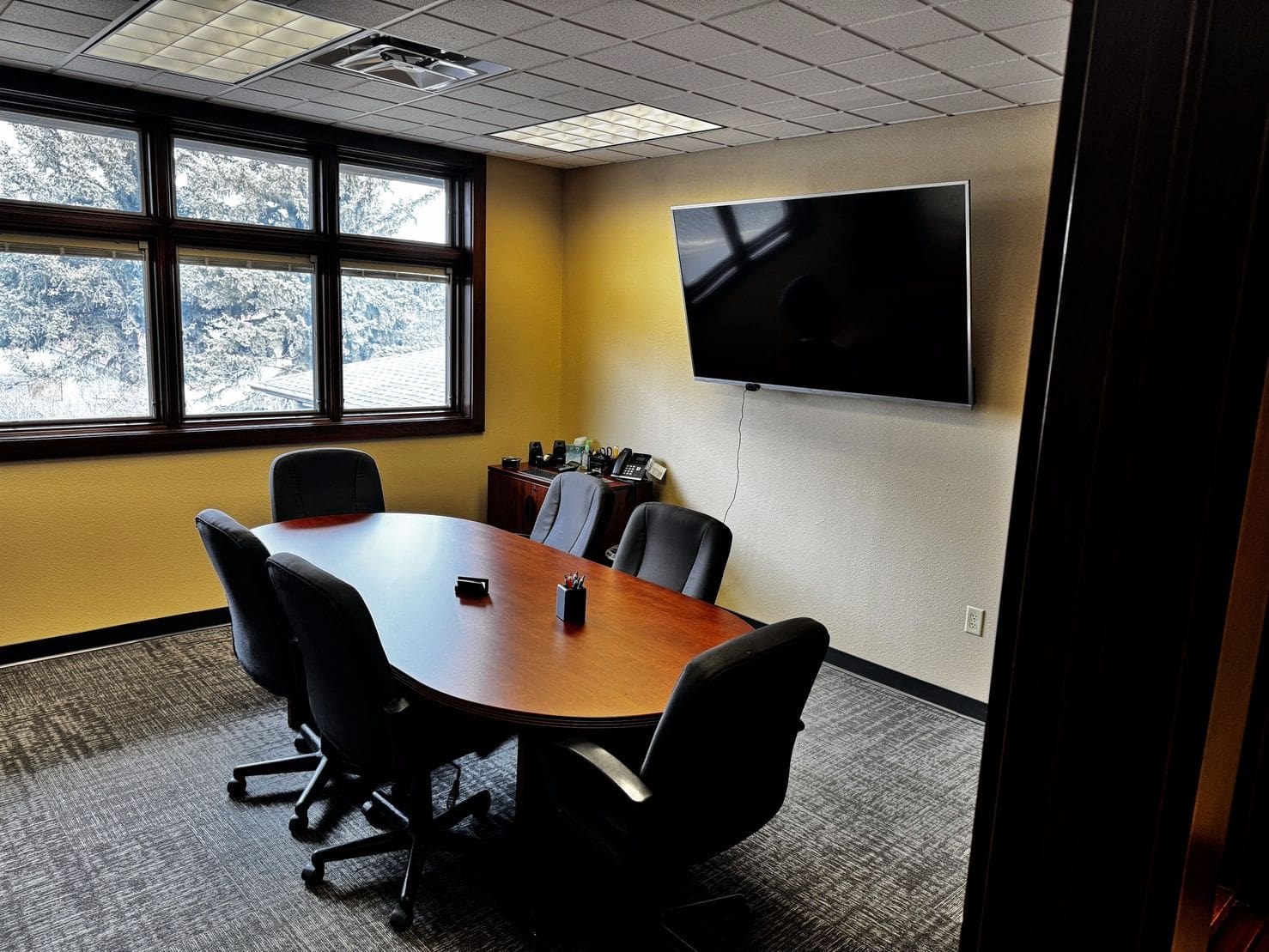 A conference room with a large table and chairs.